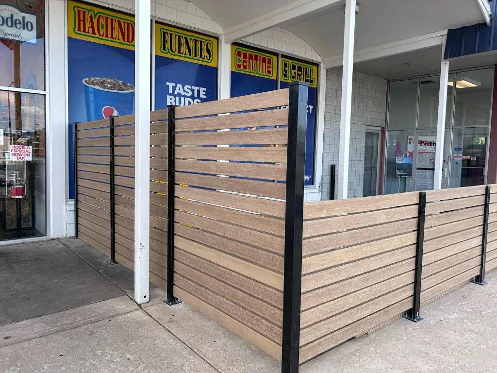 Outdoor patio with modern horizontal slat composite fencing in front of a restaurant East Peoria, IL Top-Rated