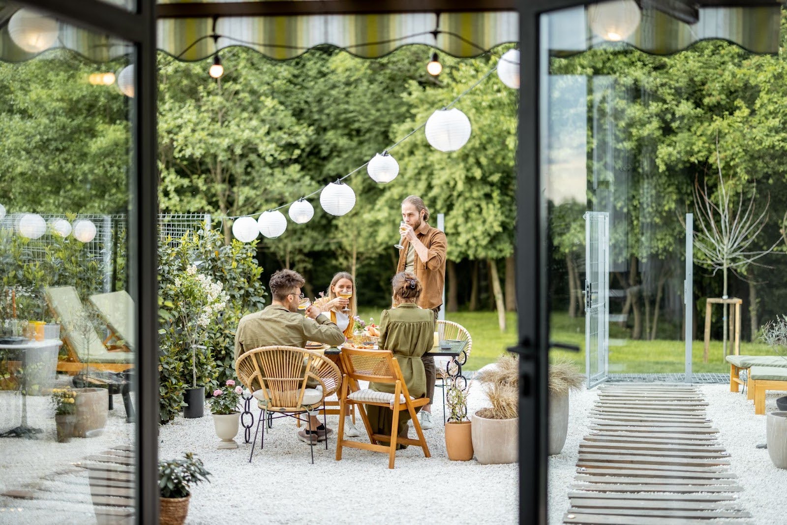 A group of friends have a get-together in a modern backyard patio.