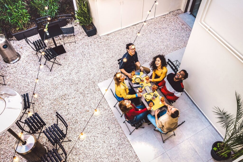 A top view of a group of friends enjoying a meal on an outdoor patio.