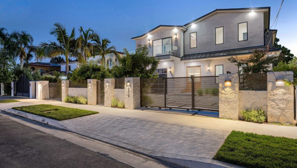 Residential property featuring a lush garden framed by sturdy metal entry gates.