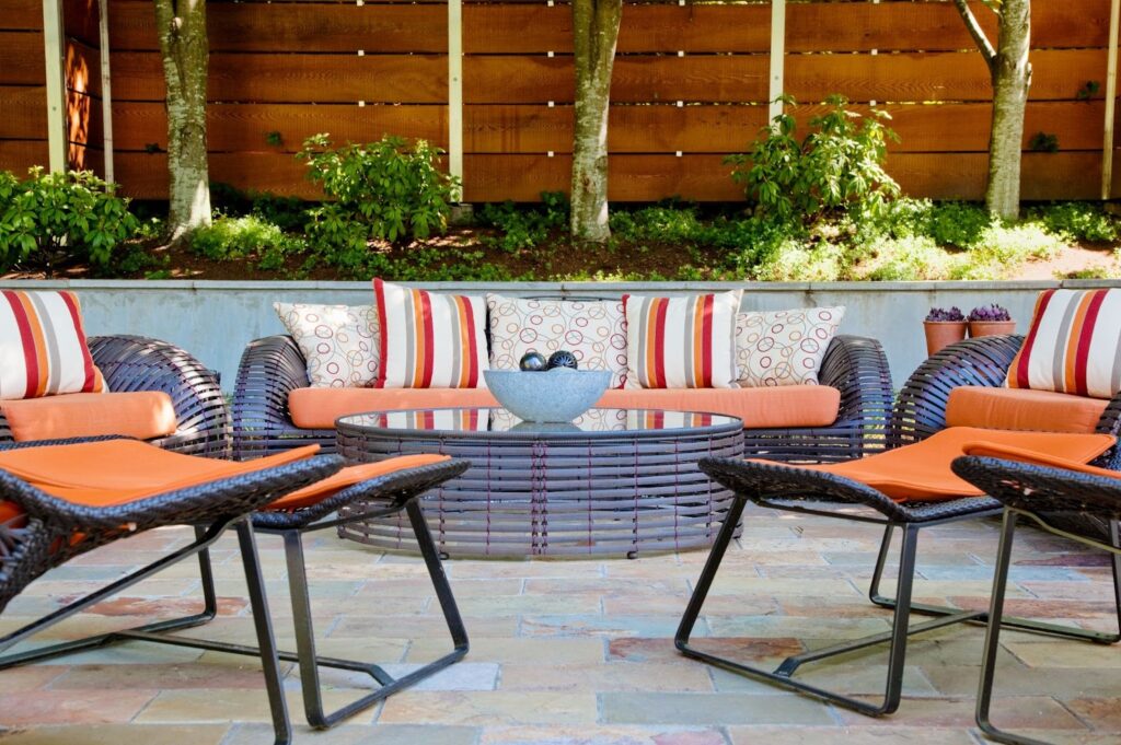 Elegant patio featuring luxury outdoor furniture with plush cushioned seating, a modern coffee table, and refined finishes.