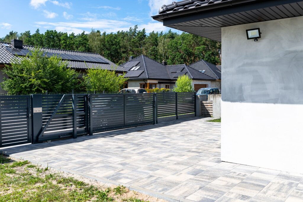 Modern anthracite panel fence with a sliding garage gate and matching pedestrian wicket gate