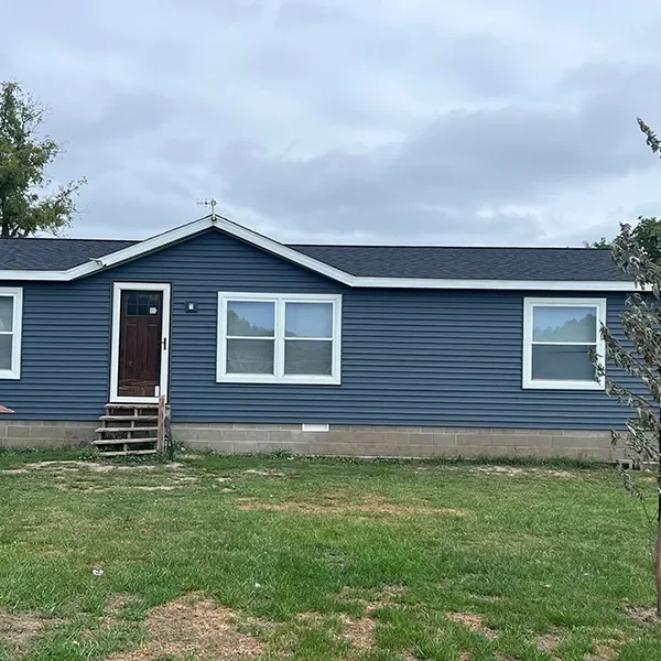Single-story house with dark blue siding, white trim, and a small front porch.