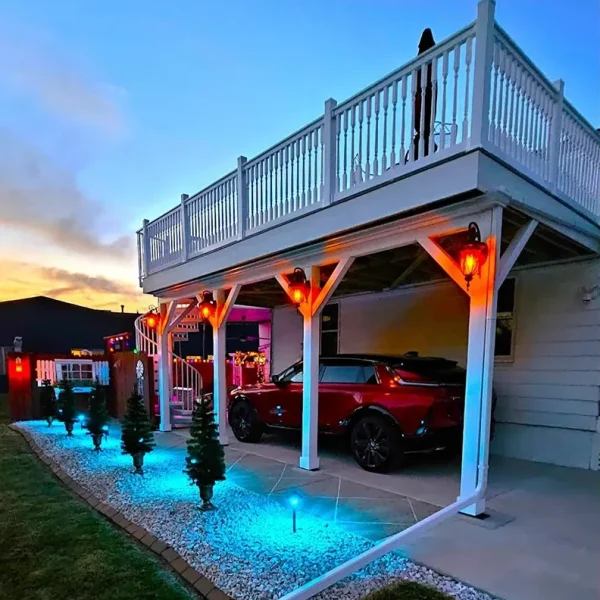 House exterior at dusk with vibrant blue pathway lighting and orange accent lights on the porch columns.