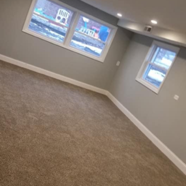 Newly carpeted room with freshly installed white framed windows and recessed lighting.